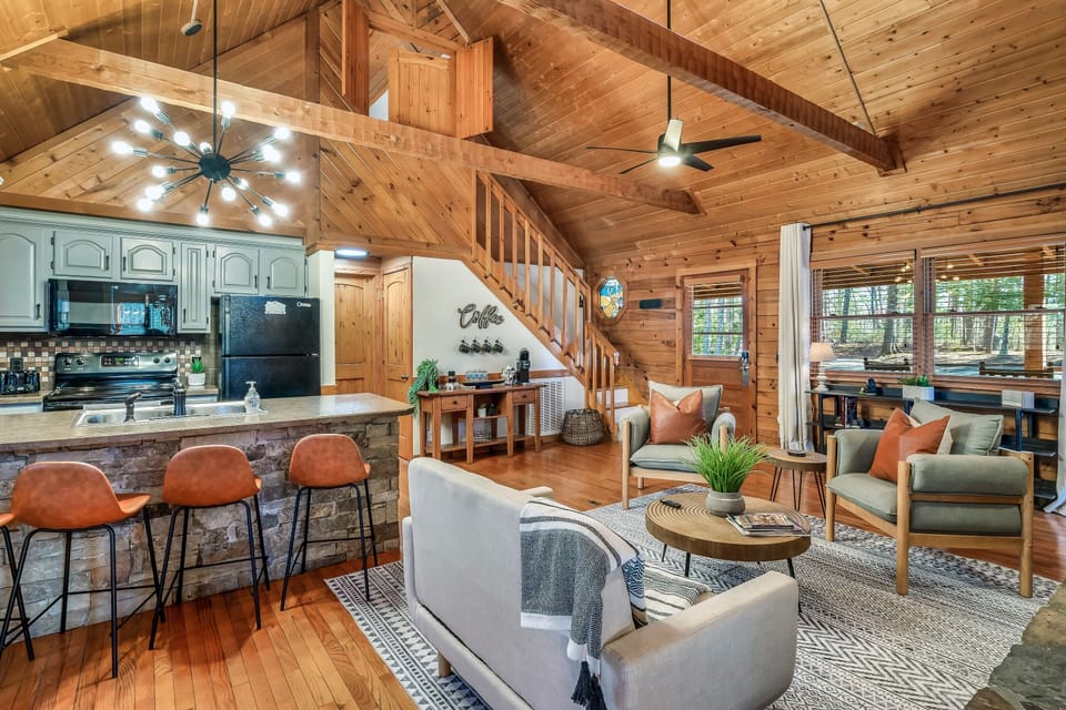 In the heart of this cabin lies a cozy kitchen, perfectly positioned near an inviting fireplace. Lounging around for quality family time is made easy with comfortable seating for everyone. 