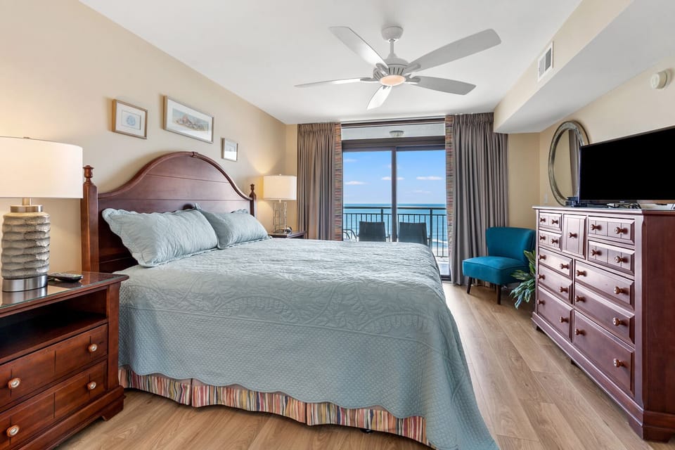 Bedroom with an ocean view and sliding door to the balcony at Beachwalk Villas 203, a 3-bedroom rental