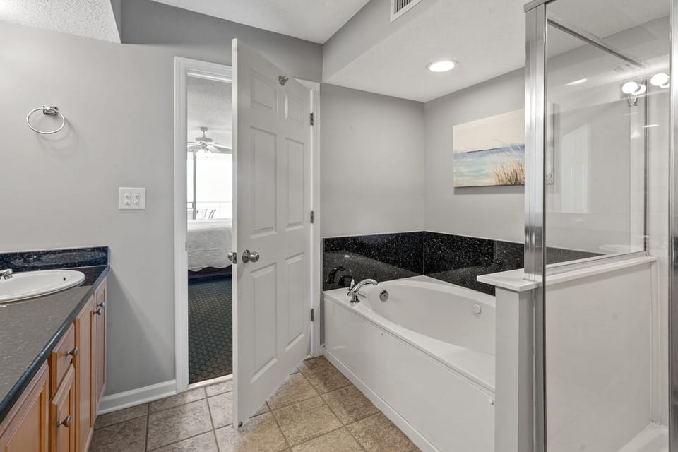 Bathroom with a soaking tub, walk-in shower and a vanity at Crescent Shores 1807, Crescent Beach, North Myrtle Beach