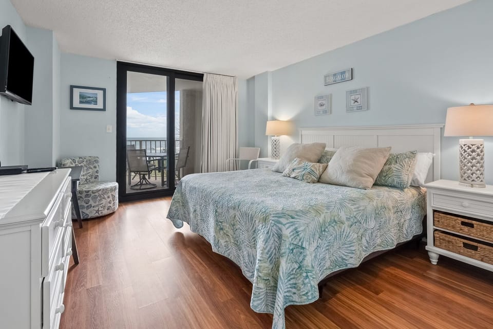 Bedroom with sliding doors to the ocean-view balcony at Crescent Sands of Windy Hill C2 in Windy Hill