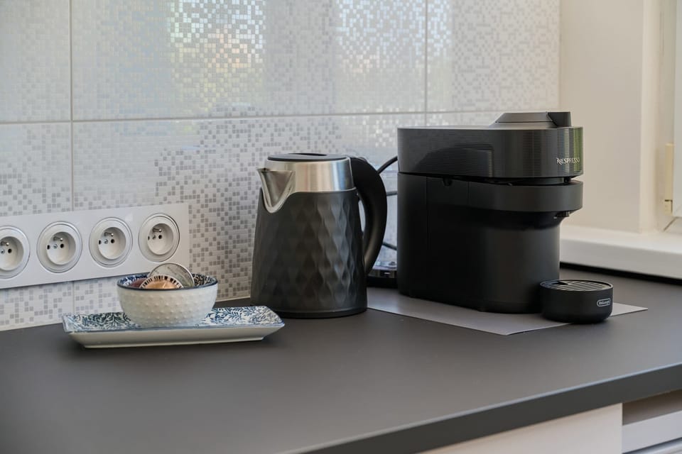 A close-up of a stylish countertop in the kitchen, complete with a coffee maker and elegant kitchenware.
