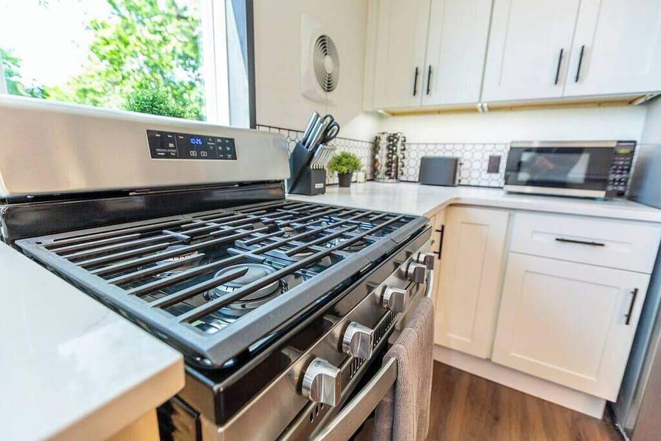 Explore your culinary skills with our kitchen featuring a gas range burner and a convenient microwave oven, ensuring seamless cooking experiences.