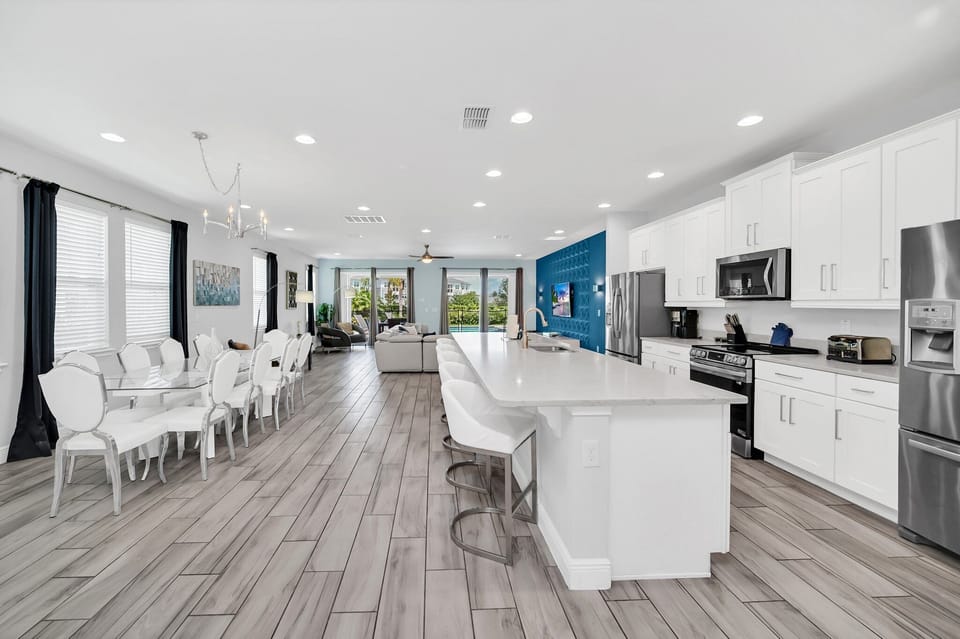 Spacious, modern kitchen with a large island and dining area, perfect for family gatherings or entertaining guests.