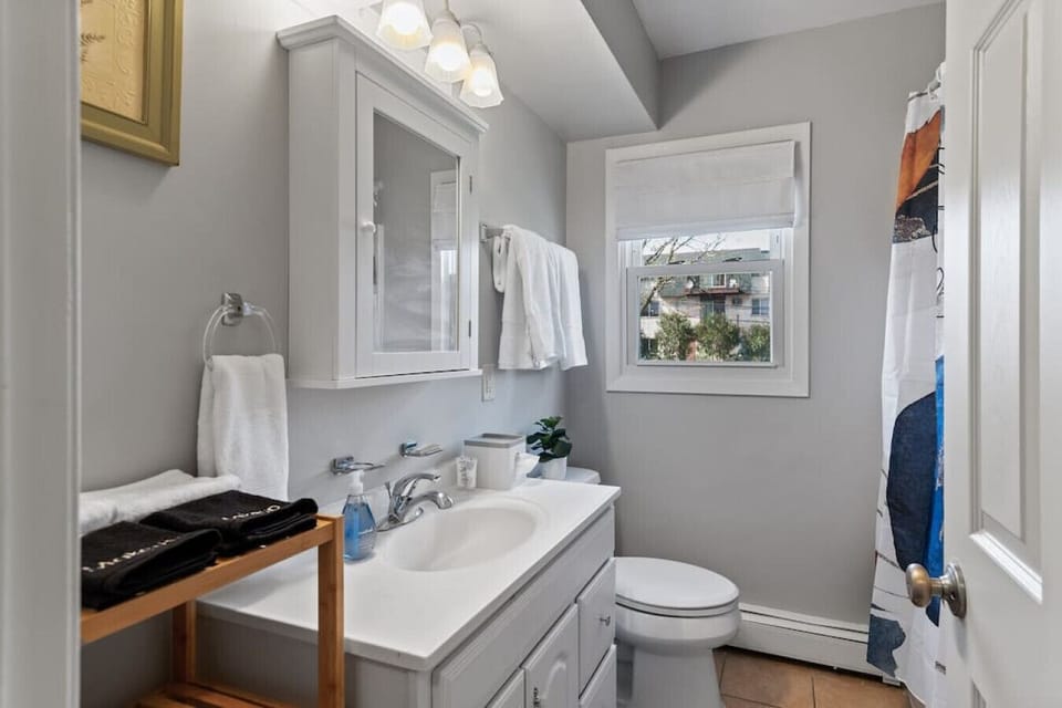 Bathroom - full bathtub with shower with makeup and towel rack.