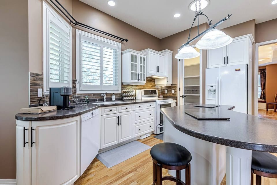 Kitchen area and pantry with a coffee machine, spices, fridge, dishwasher, electric cooking range
