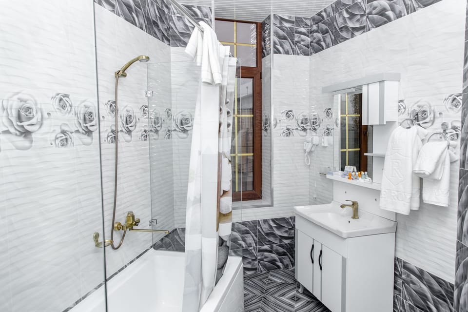 Deluxe Quadruple Room | Bathroom | Rainfall showerhead, hair dryer, bathrobes, slippers