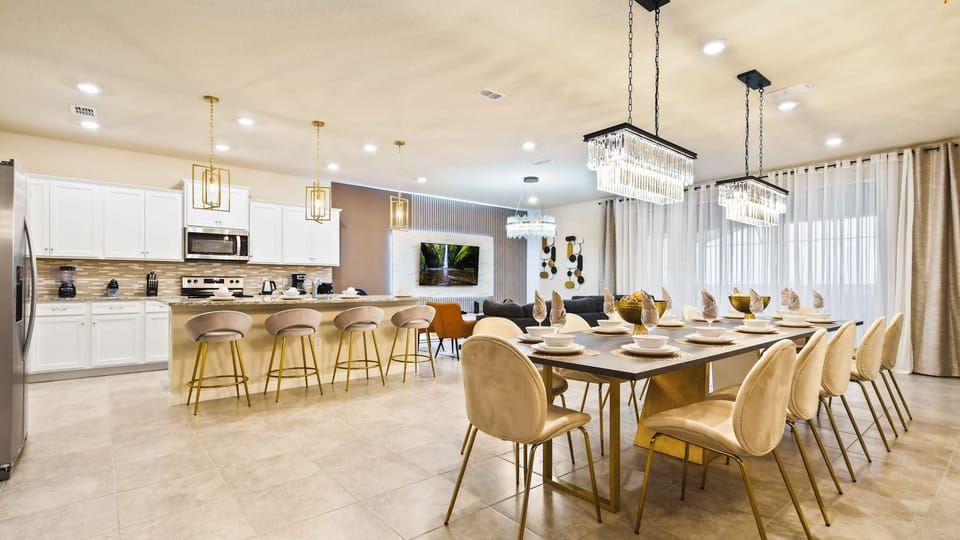 Elegant open-concept kitchen and dining area with chic lighting for group gatherings.
