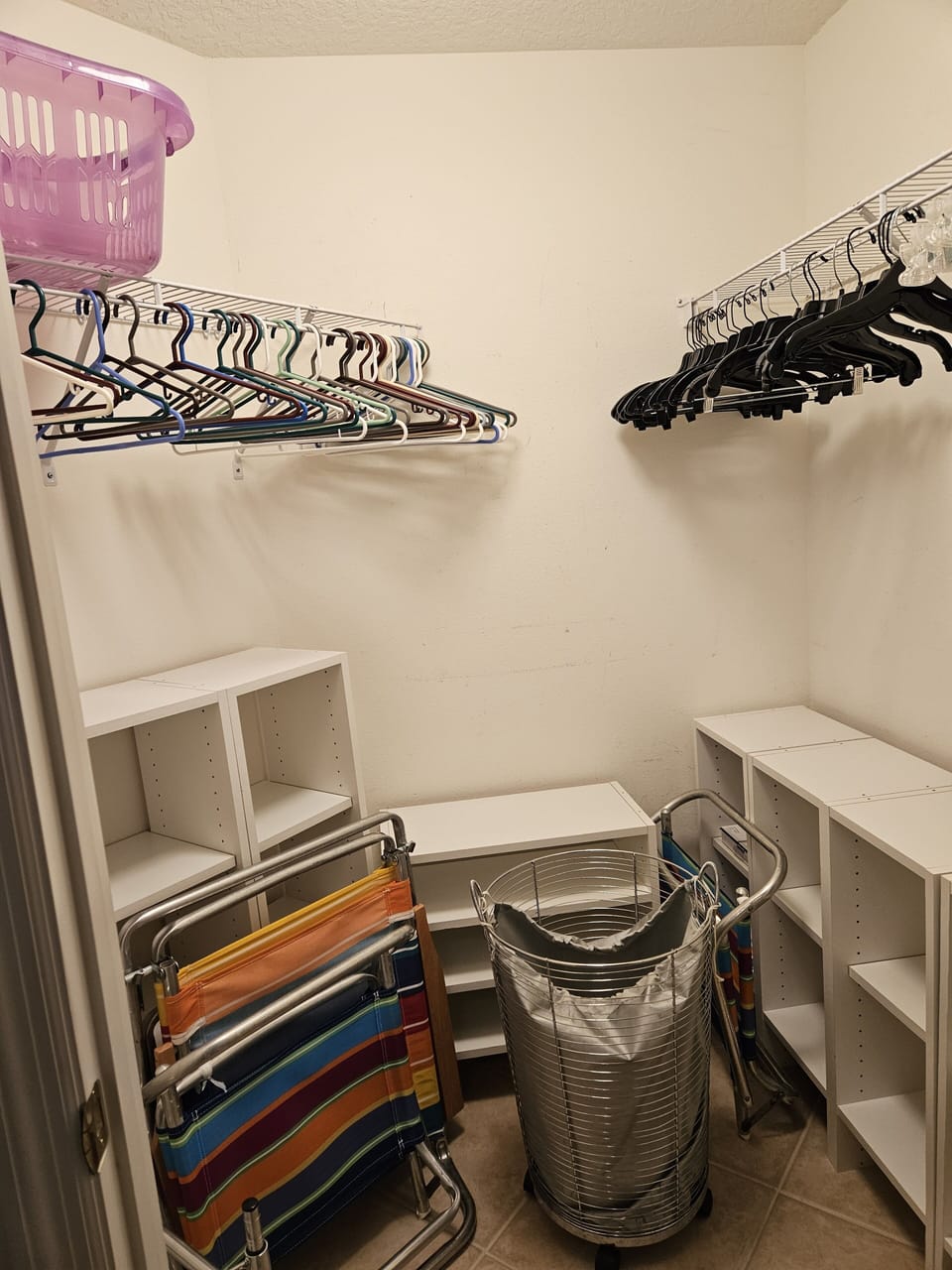 Bedroom 2 closet with laundry hampers, beach chairs.