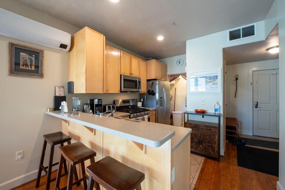 Fully equipped kitchen with stainless steel appliances and counter seating  