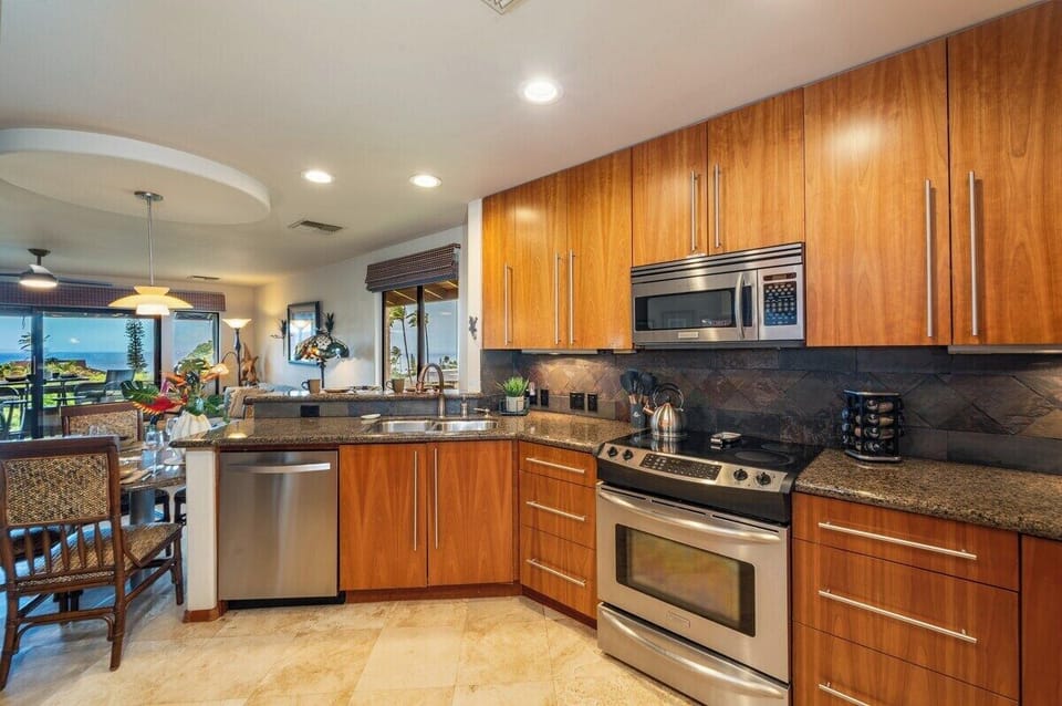 Open kitchen featuring modern appliances, ample counter space, and natural wood finishes, perfect for preparing meals in paradise.