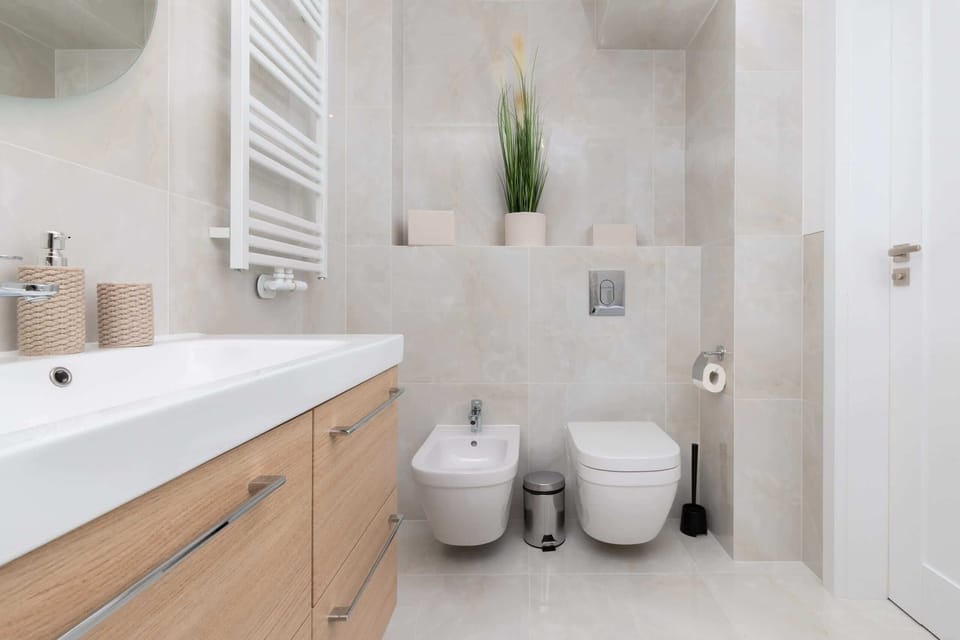 The bathroom's contemporary design includes fresh towels and a hairdryer. 