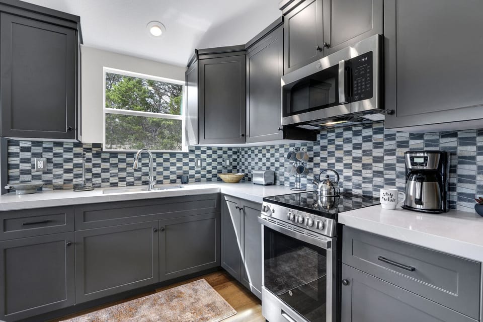 Close look at the kitchen with stainless appliances.  The kitchen has a range with over and microwave.