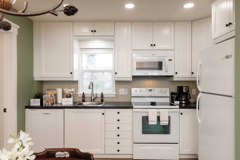 Your fully equipped kitchen awaits with crisp white cabinetry, modern appliances, and thoughtful touches that make cooking feel like home.