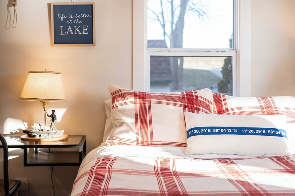 Drift into peaceful dreams with cozy plaid bedding and gentle lake-inspired decor creating your perfect retreat.
