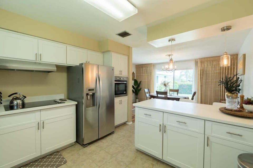 Modern kitchen with stainless steel appliances and a bright dining area.
