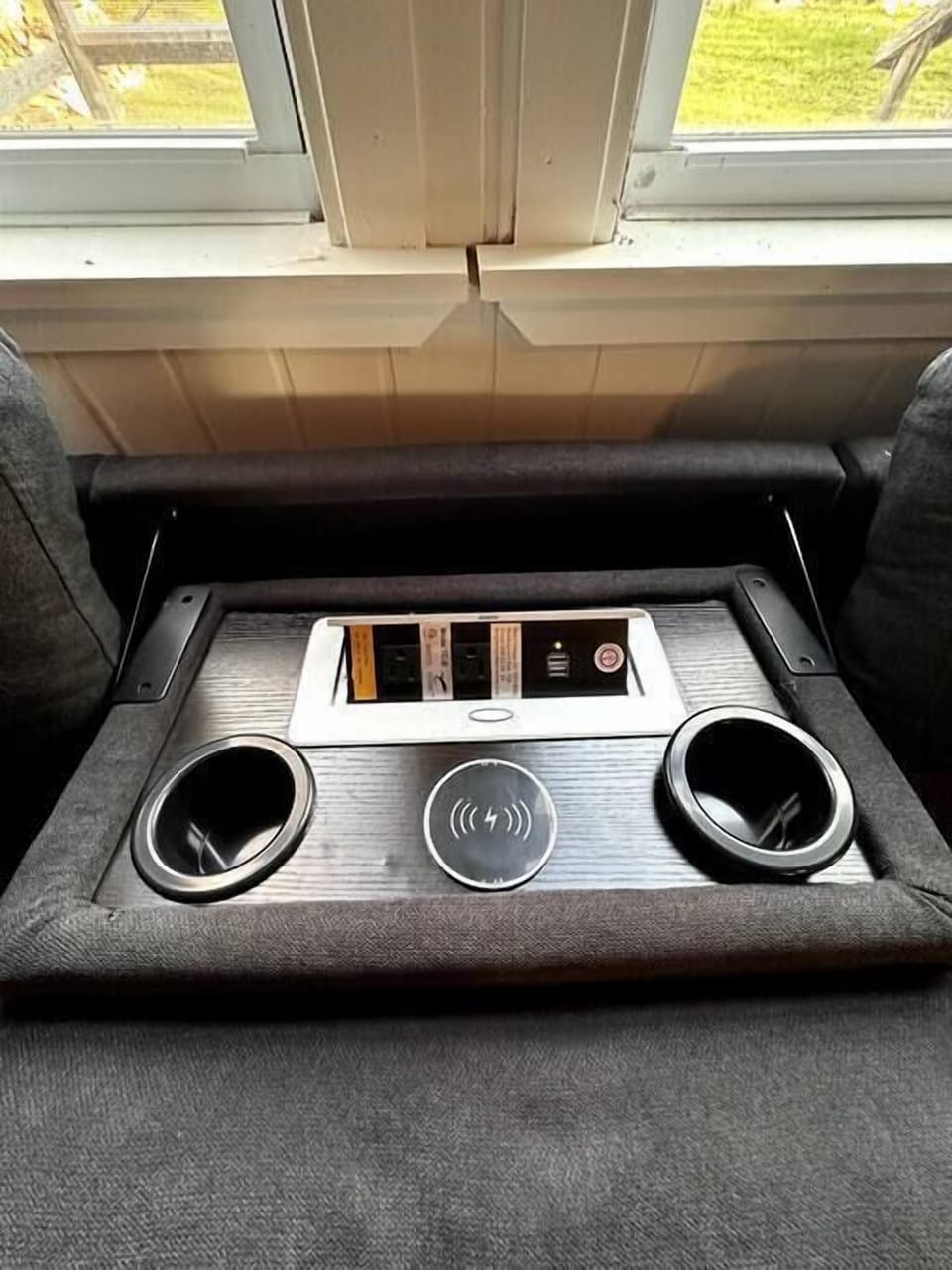 Charging port and cup holders in the couch! Even has a wireless charger!