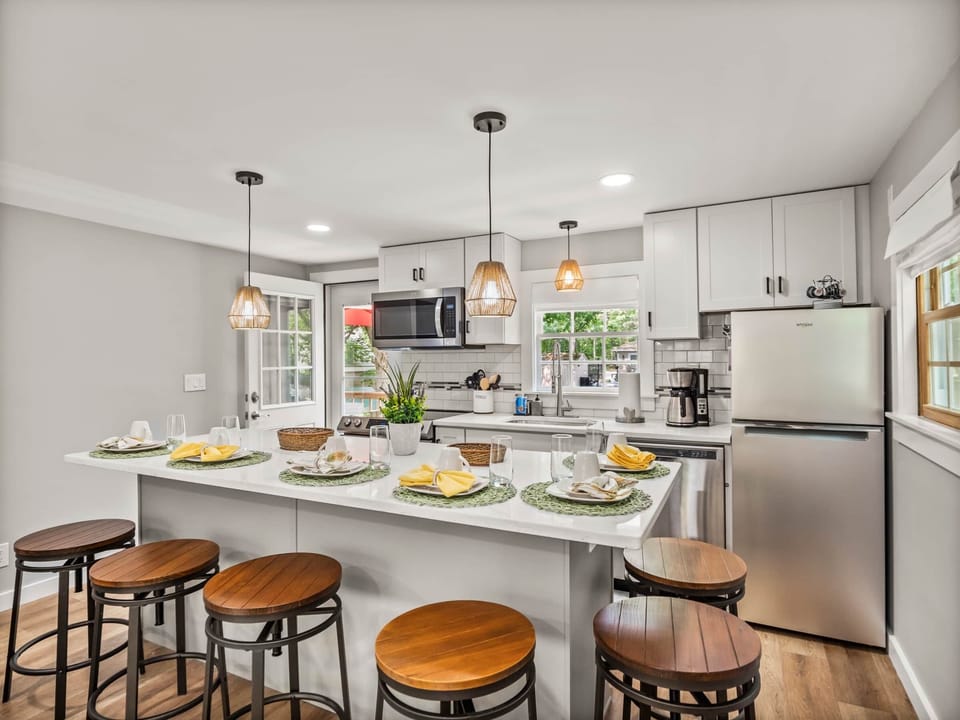 Modern kitchen with a large island, seats 6. Stainless steel appliances, fridge and mic