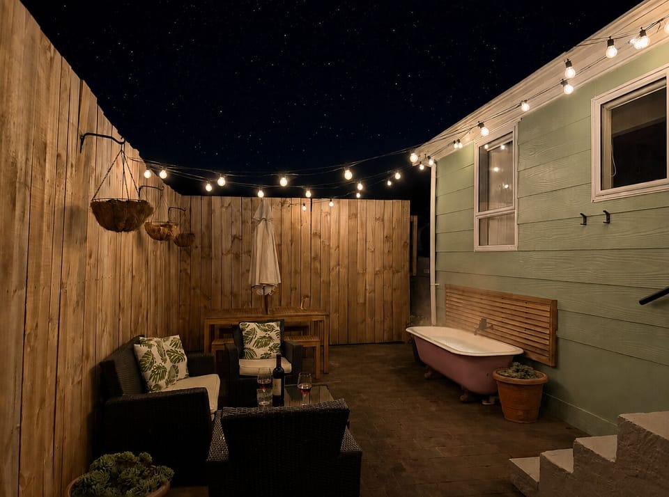 Private patio with string lights, lounge seating & a unique outdoor soaking tub