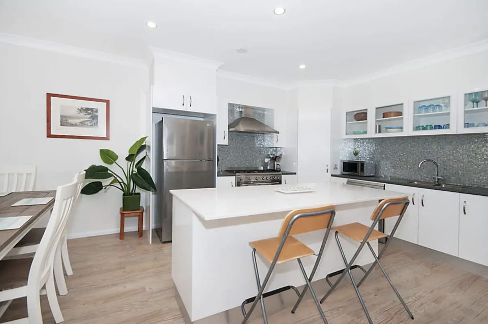 Kitchen. Oversize gas stove, SS appliances, stone bench top glass tiles. Fully equipped!