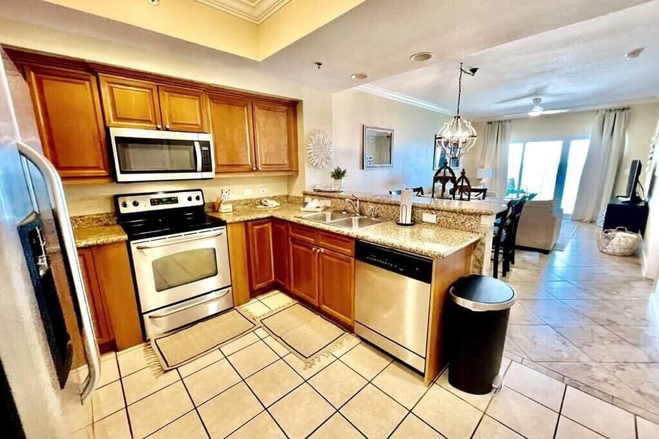 Open concept kitchen with granite counters and stainless steel appliances. Fully stocked with everything you need to cook a full meal.