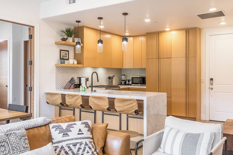 Fully-equipped kitchen with barstool seating at the counter.