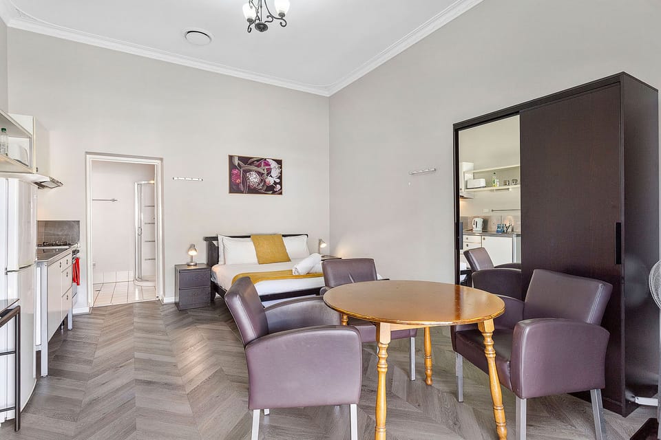 Enjoy meals and conversation at the inviting dining table, surrounded by natural light and a warm ambiance.