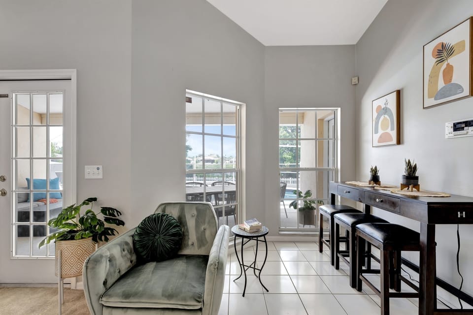 The grandeur of the space is amplified by the expansive floor-to-ceiling windows that flood the room with natural light, creating a seamless connection between the indoors and the beauty of the surrounding landscape.