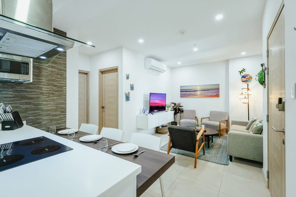 Cozy living room with comfortable seating, smart TV, natural light, and inviting atmosphere.