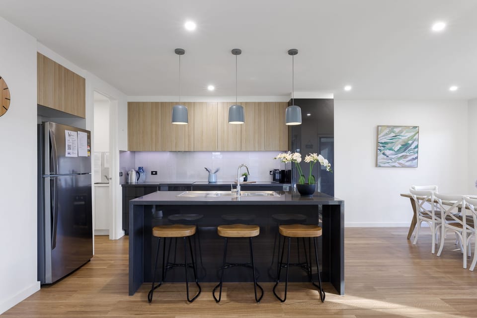 Kitchen with island bench and three stools