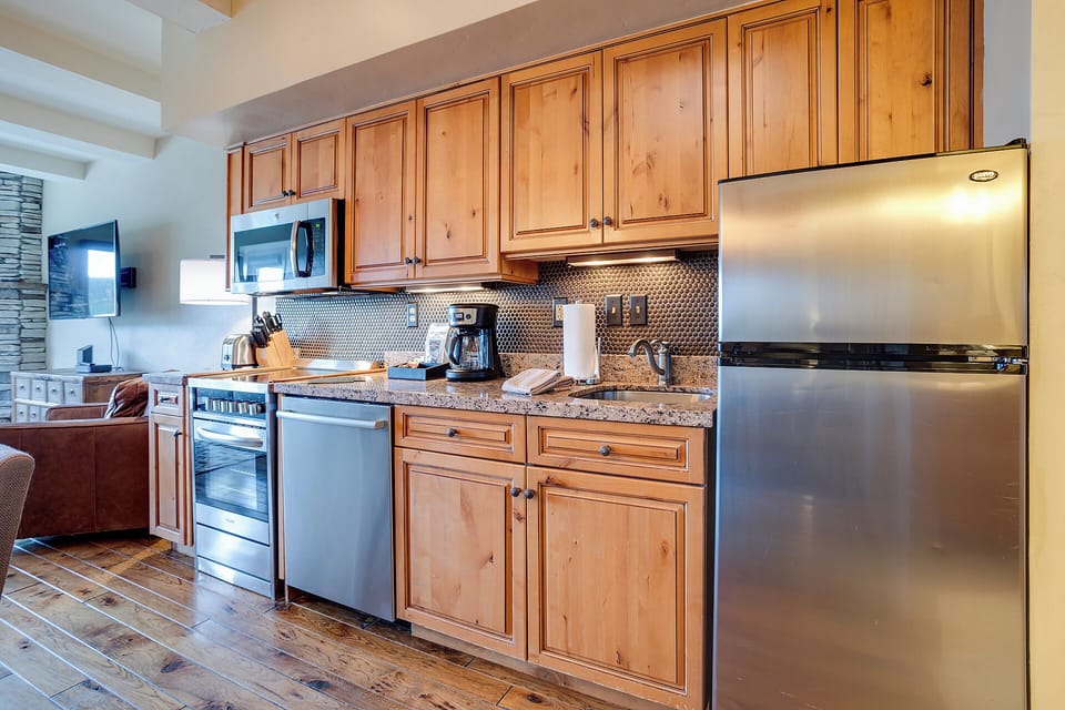 Your fully equipped kitchen features granite counters, stainless appliances, and warm wood cabinets for creating memorable meals together.
