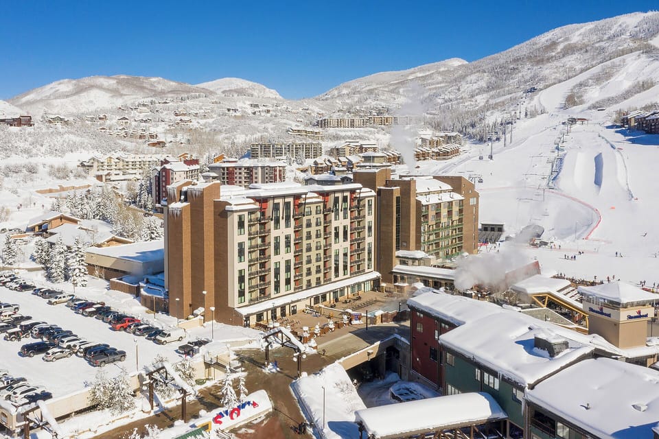 A mountain village nestled in forested hills, featuring a community playground and recreational areas in the surrounding neighborhood.