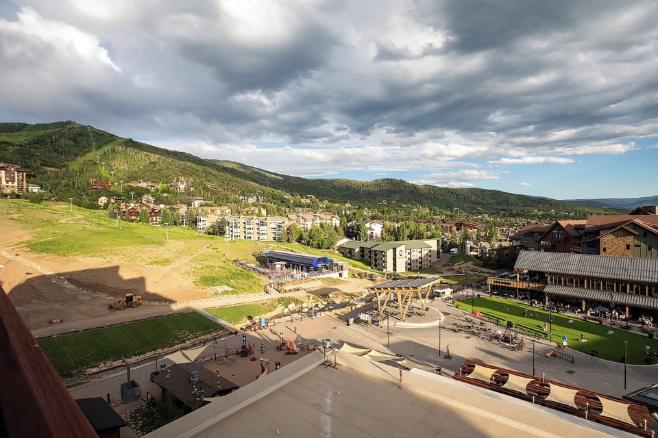 Mountain resort area featuring recreational facilities and residential buildings nestled in a scenic valley setting.