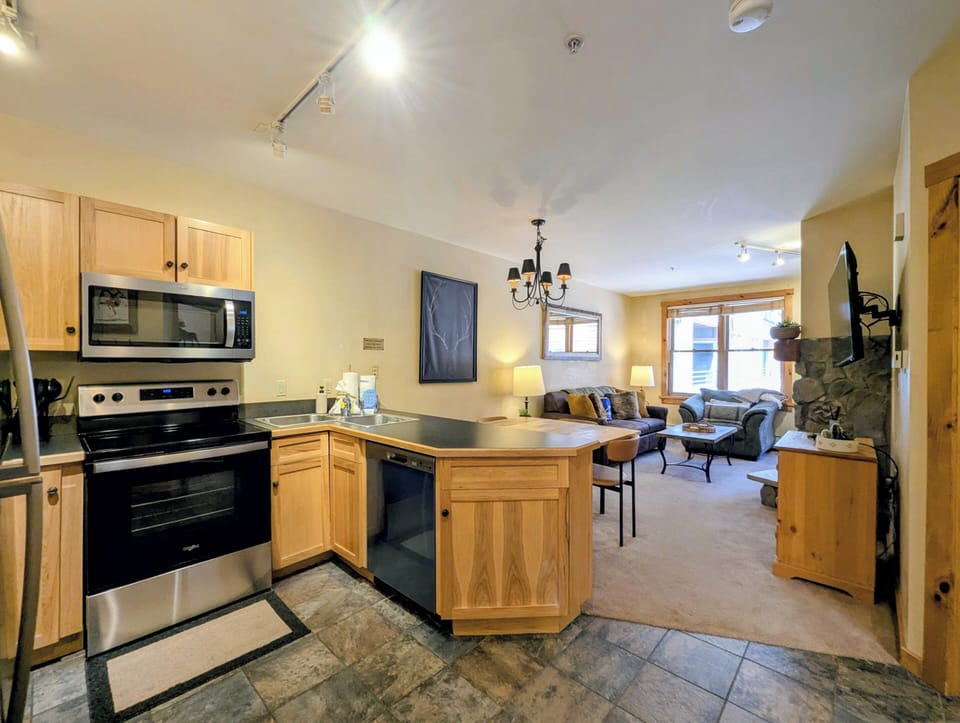 Your open-concept retreat features a well-equipped kitchen with modern appliances flowing seamlessly into a cozy living area—ideal for relaxing after a day of adventure.