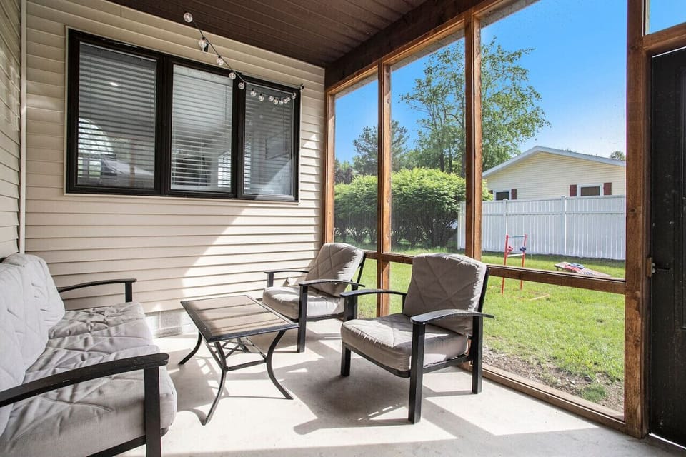 Screened-in patio with seating and string lights