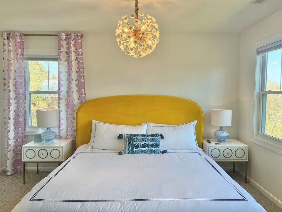 Primary bedroom features brand new King bed, picture window view of mountains (not shown here), 50” mounted flat screen smart tv, small walk-in closet and full en suite bath with tiled tub shower 
