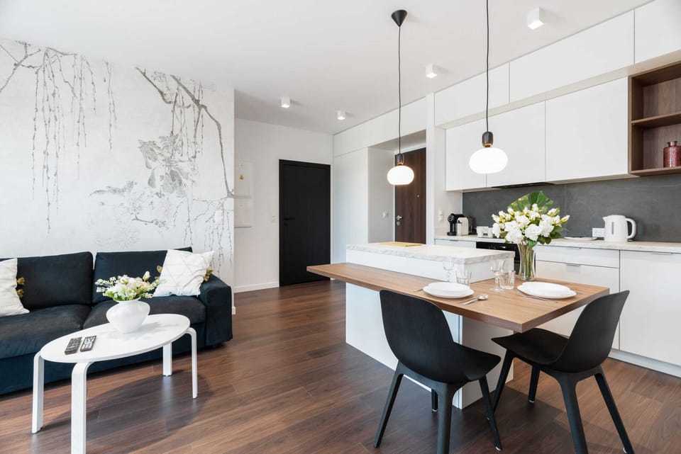 The living area features a sleek coffee table and a flat-screen television.