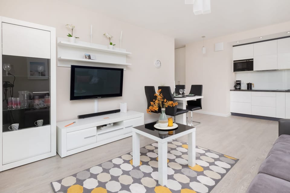 Another angle of the living room showcasing a sleek entertainment unit with a flat-screen TV and decorative elements.