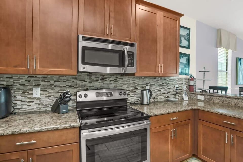 Elevate vacation dining in this fully furnished chef's kitchen, featuring stainless steel appliances, generous counter space, and everything needed to prepare anything from a quick breakfast to a memorable family dinner.
