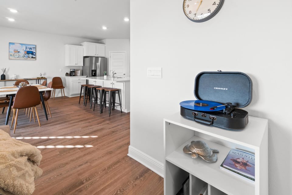 Gather around your open-concept kitchen and dining area where modern meets comfort, complete with a vintage record player for your evening soundtrack.