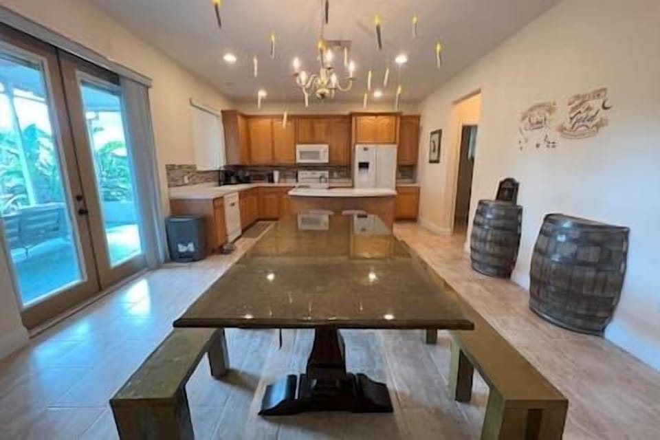 Indulge in a candlelit meal with floating candles over the custom gold dining table and custom French doors that open up to the patio. Kitchen contains all you need to create your perfect feast!