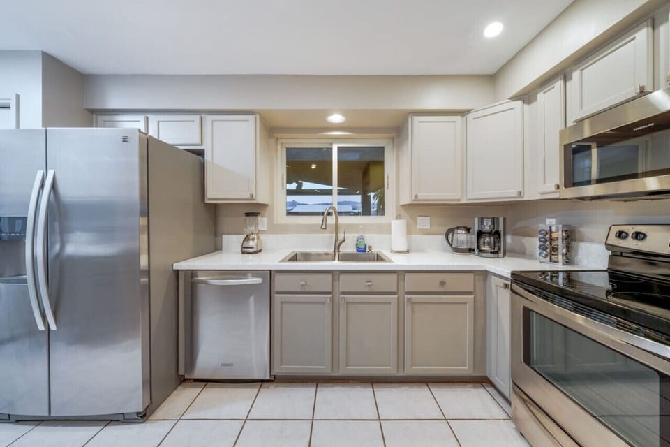 Fully equipped kitchen with stainless steel appliances (dishwasher, microwave, electric range, and refrigerator)