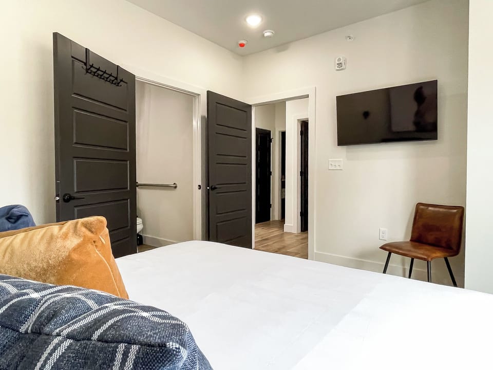 Spacious main level bedroom with tv, extra seating, and ensuite bathroom