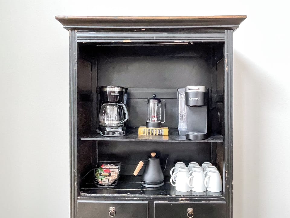 Coffee bar stocked with a coffee pot, Keurig, french press, and electric kettle