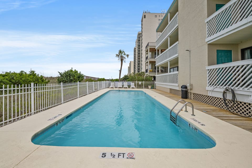 Take a cool dip in the sparkling pool after a fun day at the beach.