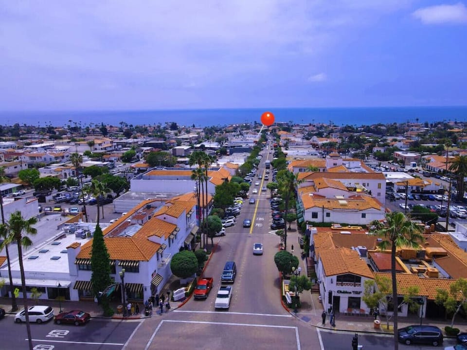 Aerial view down a bustling street leading toward the ocean horizon