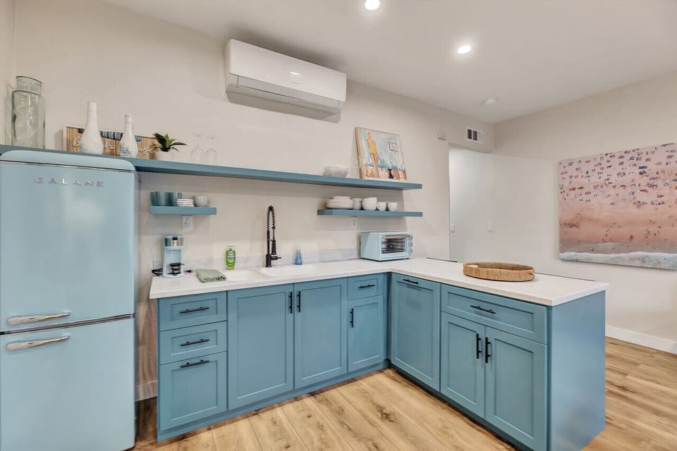 Charming kitchenette w/ blue cabinets, open shelves & modern appliances for simple meals