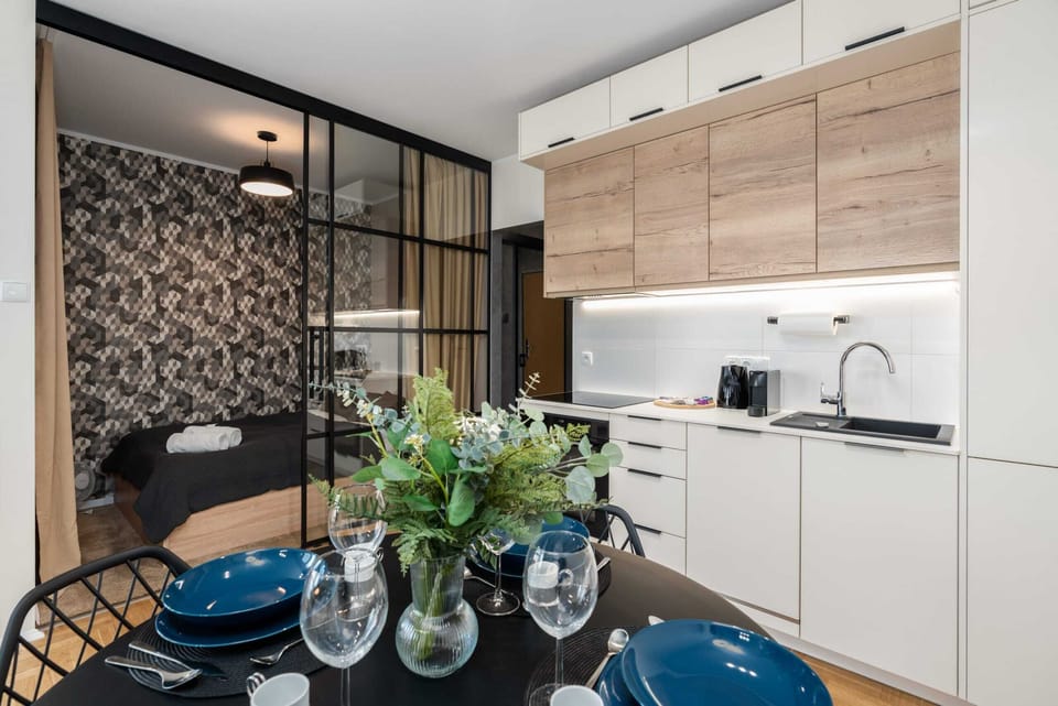 A dining area connected to a modern kitchen with light wooden cabinets.