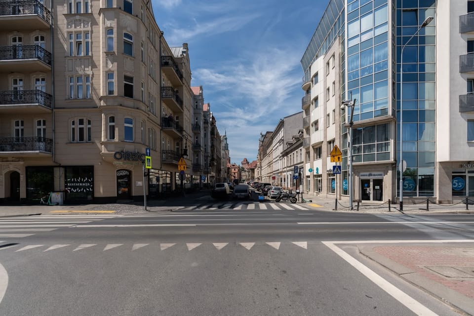 A city street view showcasing a modern building with glass elements.