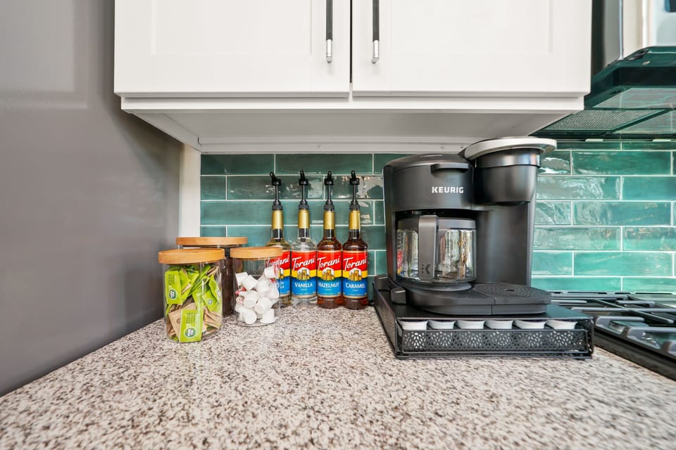 Full coffee bar offers a Keurig Duo, a French Press, an electric kettle, a grinder, a frother, coffee grinds, K-Cups, sweeteners, creamers, and flavor syrups!