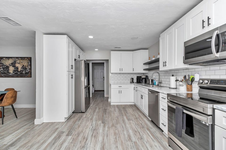 Upgraded kitchen, wine/coffee nook, recessed lights, newer appliances, pots/pans